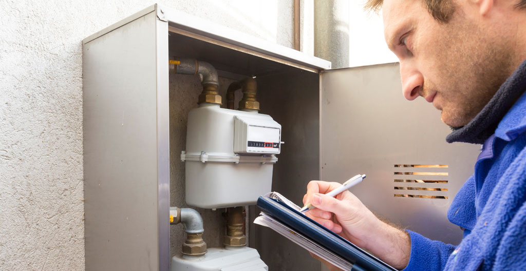 Technicien inspectant un compteur gaz industriel pour analyser la consommation entreprise