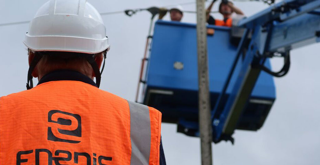Compteur Linky installé sur mur externe de bâtiment professionnel avec câblages et plaque Enedis